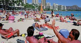 Эрэг дээр биеэ наранд шарагчид