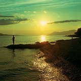 Далайн эрэг дээр нар жаргаж буй нь