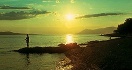 Далайн эрэг дээр нар жаргаж буй нь